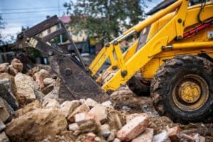 bulldozer loading demolition debris and concrete waste for recyc