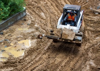 Excavator working on a muddy New Orleans construction site