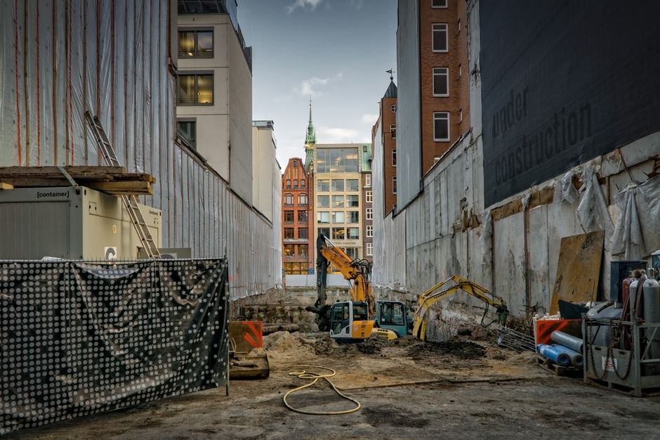 narrow New Orleans street with demolition equipment staged for a job